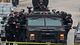 Police in tactical gear arrive via an armored police vehicle as they surround an apartment building while looking for Dzhokhar Tsarnaev in Watertown, Mass., on Friday.